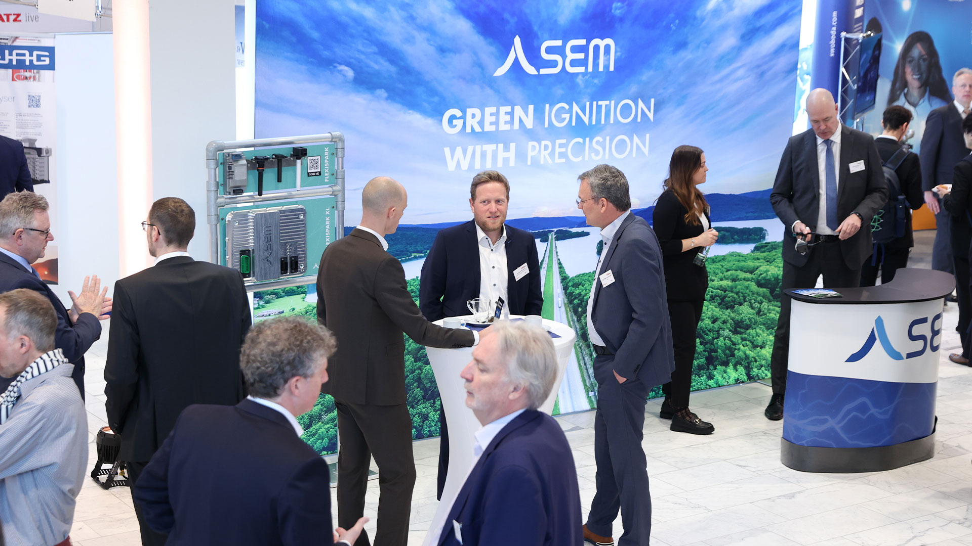 Mehrere Gruppen von Menschen im Ausstellungsbereich umgeben von Ständen und Exponaten.