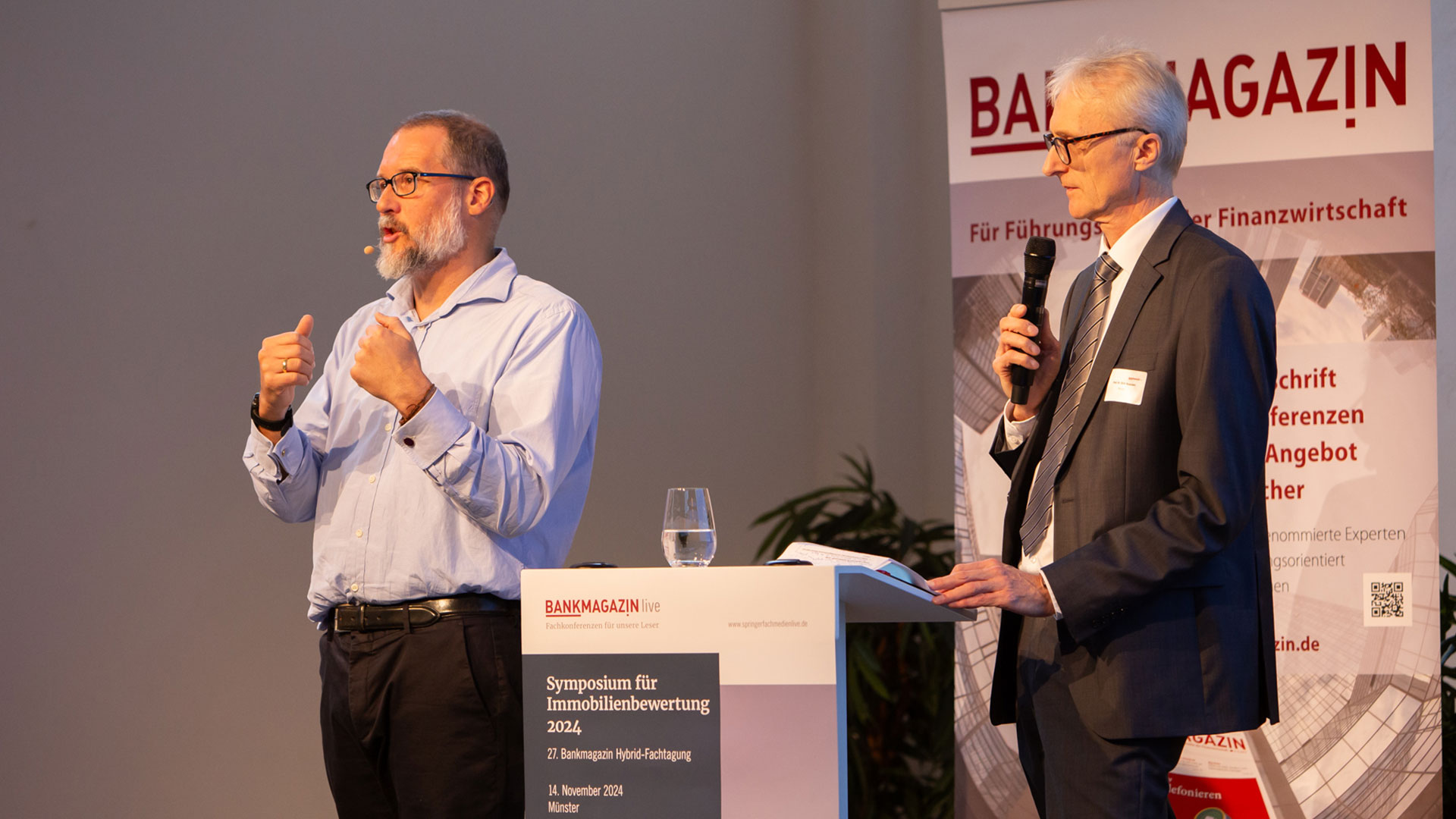 Referent und Moderator der Konferenz auf der Bühne. 
