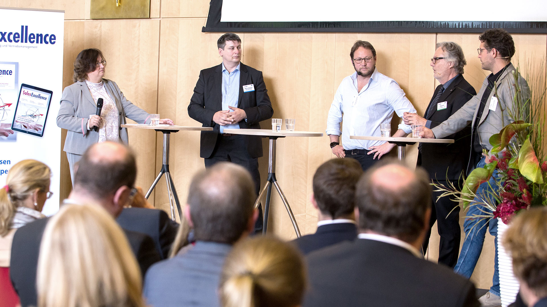 Podiumsdiskussion mit  fünf Diskutanten vor Publikum